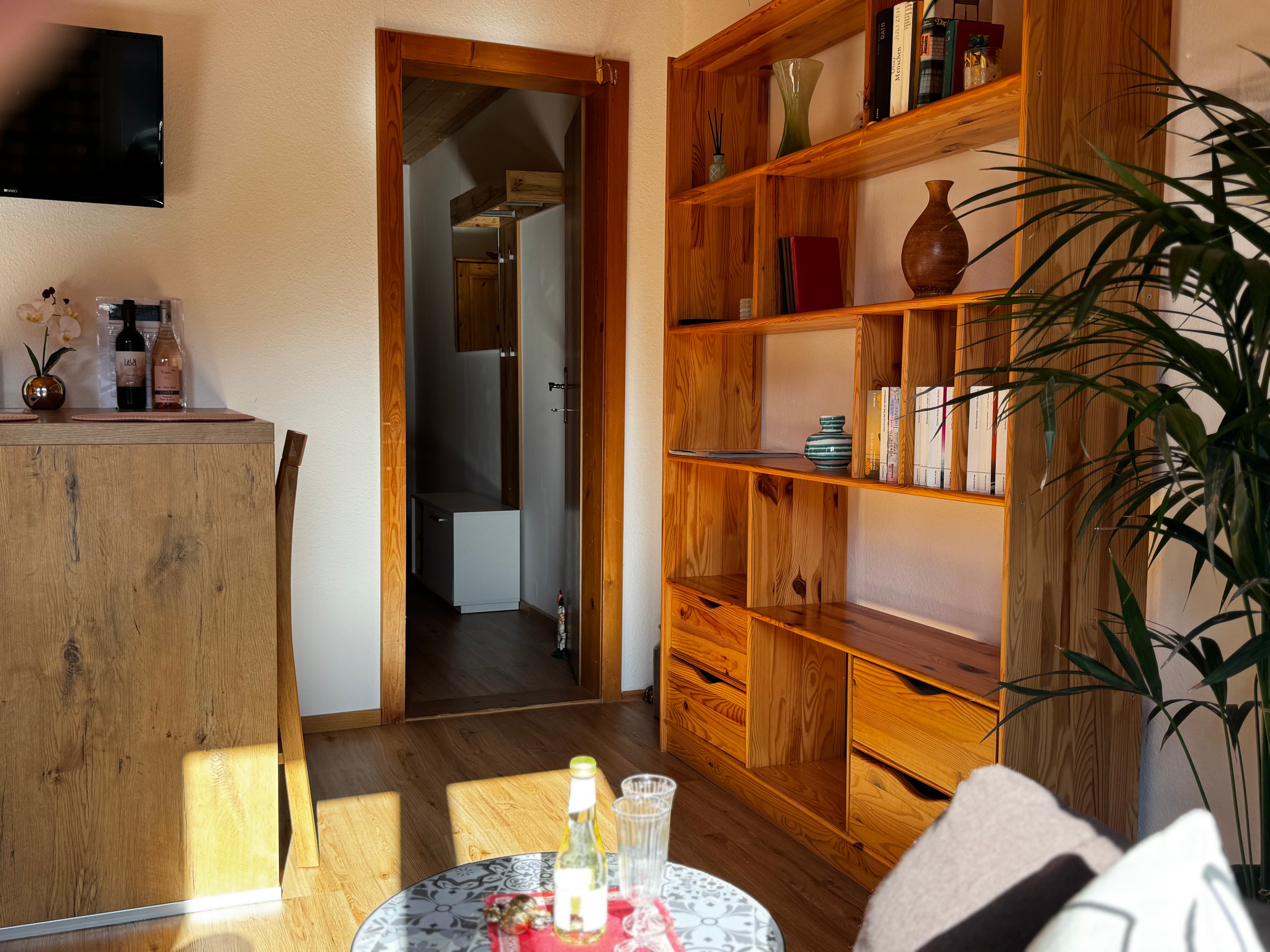 Heli's Holiday Suites | Ferienwohnung Balkon-Sandling - A modern bathroom sink area with a large mirror and a window showing a rural landscape with mountains.